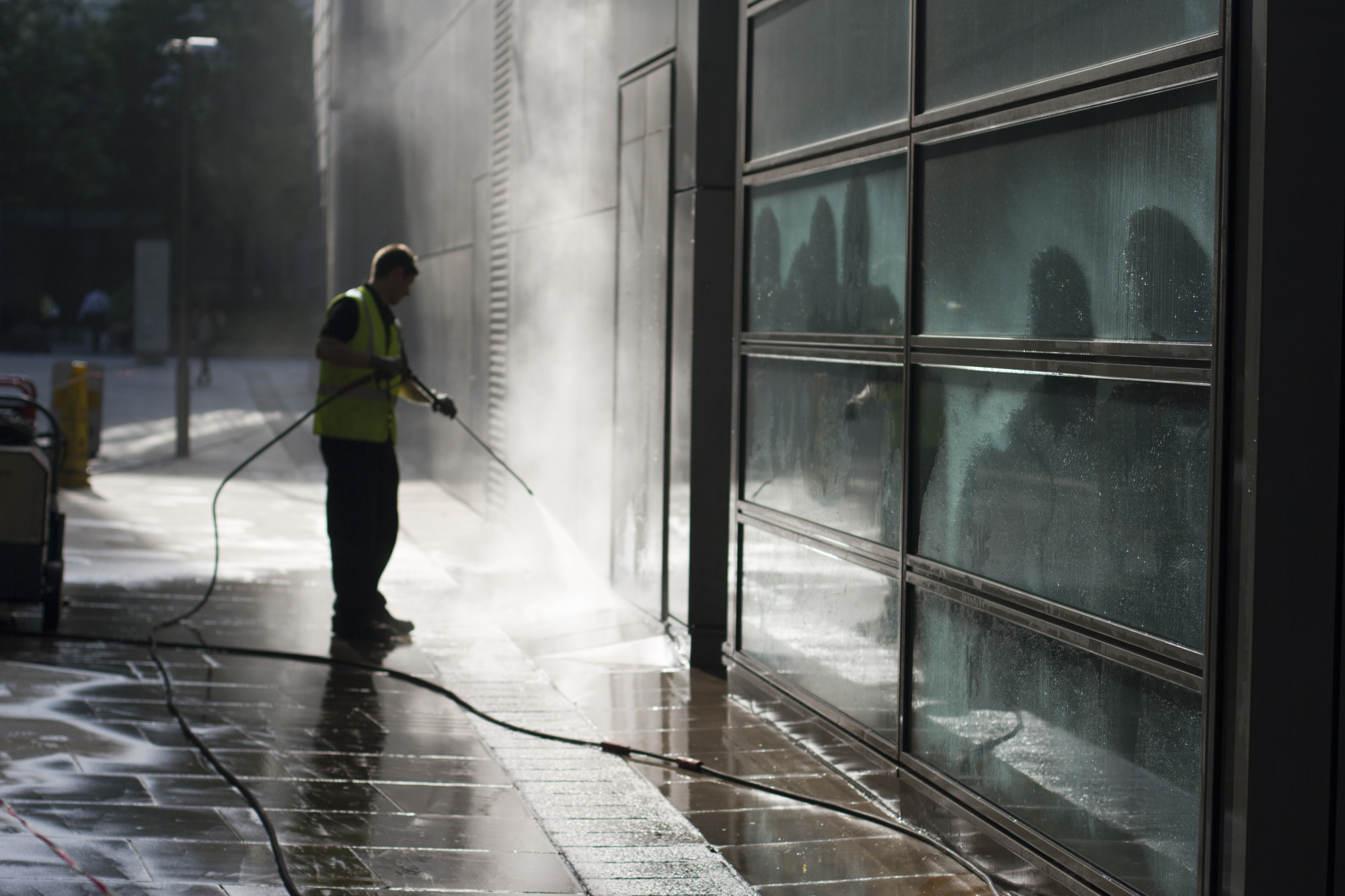 Cyclone Powerwash technician power washing a commercial building